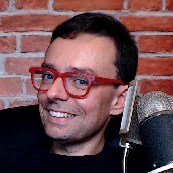 image of man smiling with red glasses Aderson